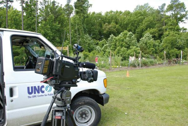 Photo of a news station videotaping at a community garden.