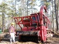 Red-metal bull dozier sized biomass harvester roughly tank-size