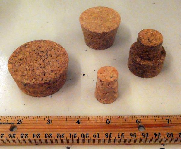 Various sizes of corks next to a ruler for scale