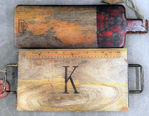 Cutting boards, one has a red patterned handle, one is engraved with the letter "K"