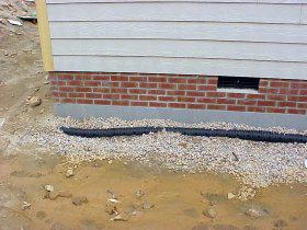 A foundation drain being installed around a new home