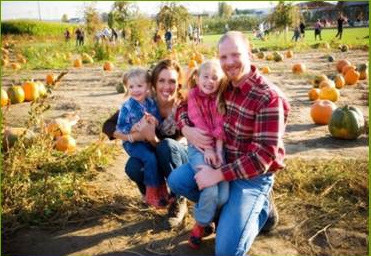 Family poses in pumpkin patch