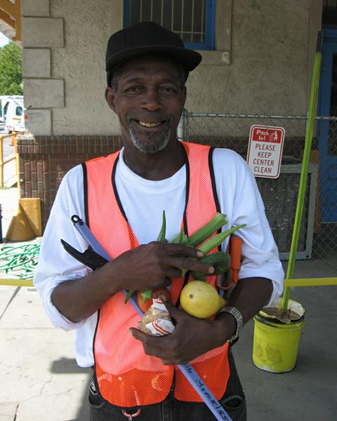 Person in orange vest holding vegetables