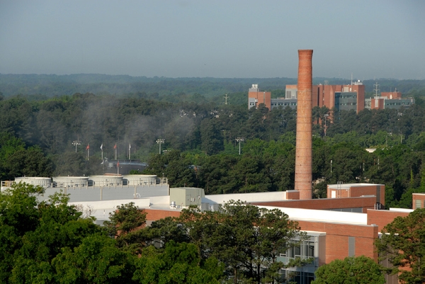 Photo of buildings, trees, and a smokestack