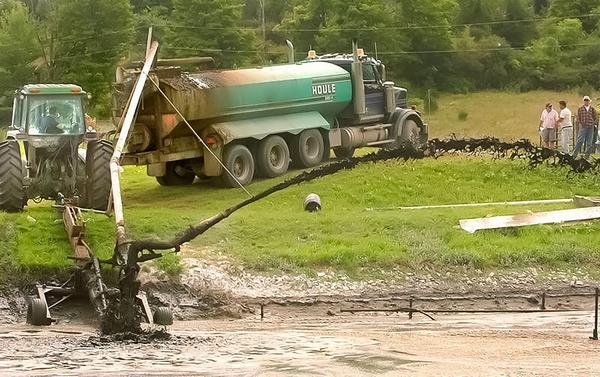 Photo of sludge being pumped from the lagoon into a tanker