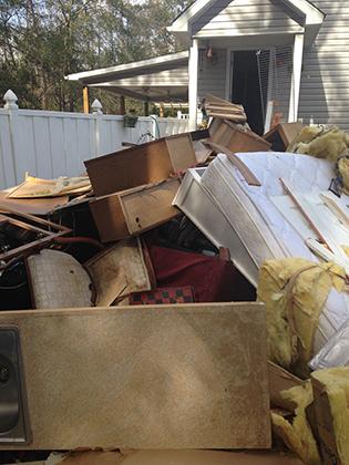 Furniture piled in front of house after flood