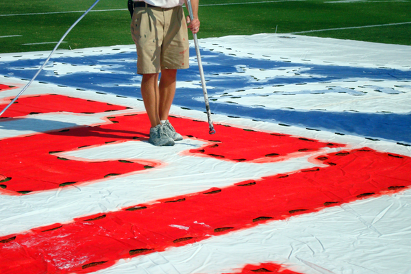 Painting a logo on a field.