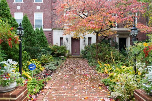 fall color plants in front of brick building with brick pathway