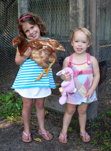 Young girls holding a chicken