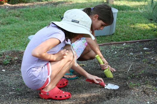 Children using trowels to dig in a garden