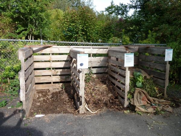 Three side-by-side compost areas made from wooden pallets