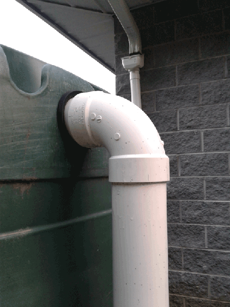 Round gasket seal around white PVC pipe entering tank