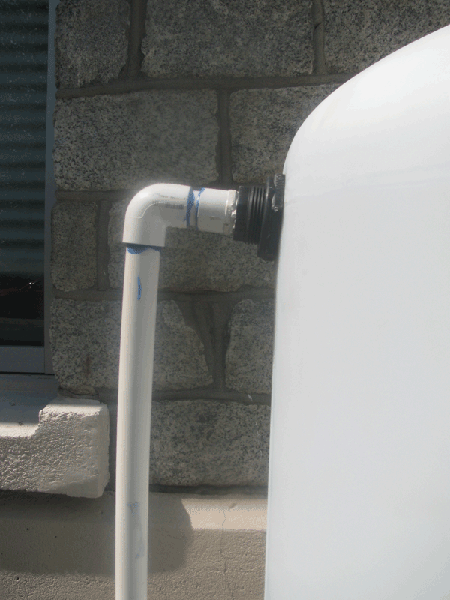 Bulkhead fitting around white PVC pipe entering tank