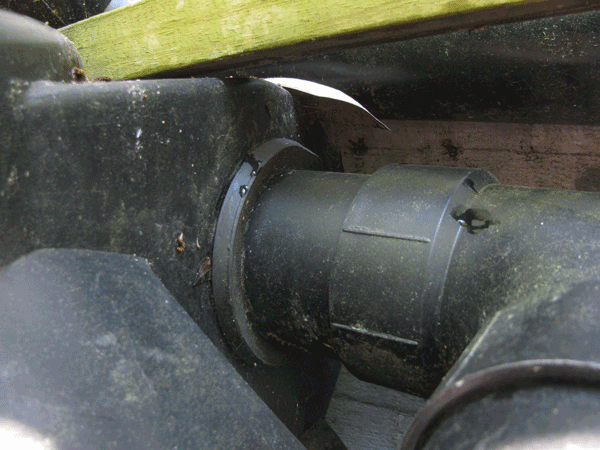 Large black pipe entering tank with cracked gasket