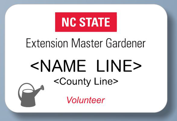 Name badge with vertical logo at the top above the name, county, and “Volunteer” with a gray watering can icon in the lower left corner.