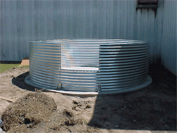 Bottom portion of corrugated metal cistern on dirt surface