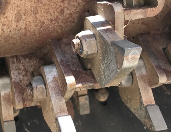 Close-up view of the vertical blades of a fraise mower.