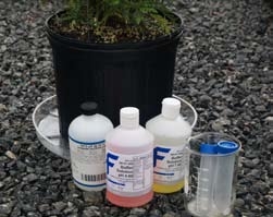 Gathered materials and supplies including beaker, vials, potted plant with saucer, etc.