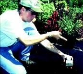 Person lifts and tips container to drain leachate