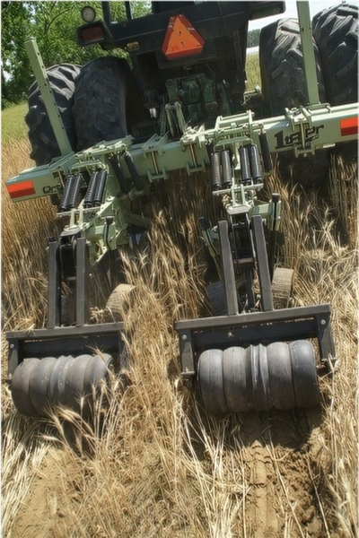Heavy strip-tiller with two roller wheels.