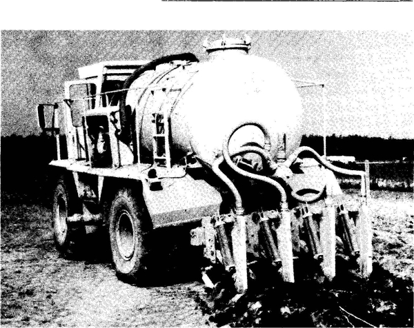 Black and white photo of truck with a tank and attachment for injecting sludge into soil