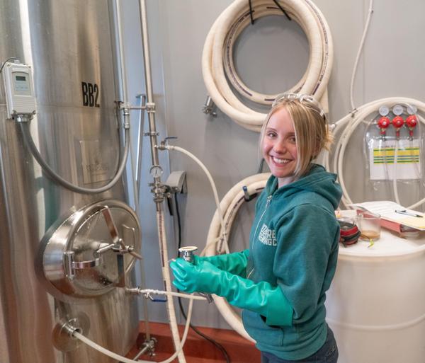 Photo of brewer checking fermentation tank lines
