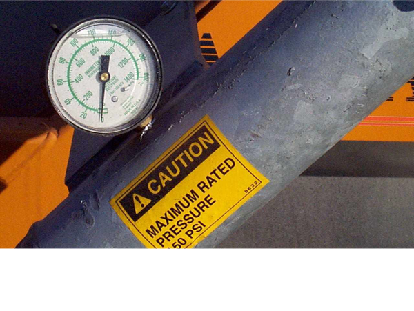 Closeup view of a pressure gauge filled with liquid and a maximum rated pressure label.