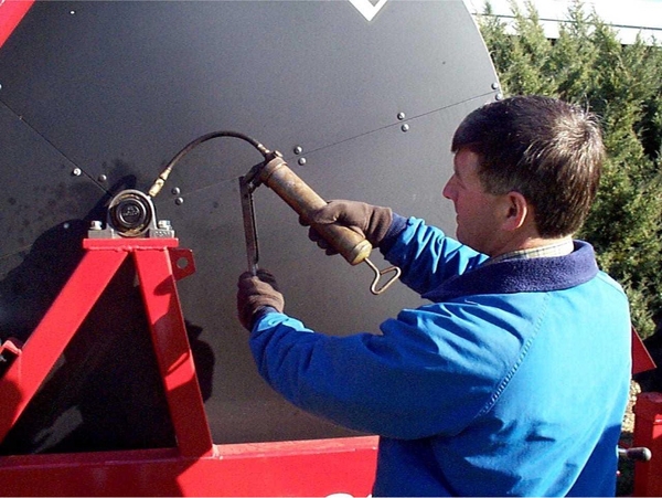 A person uses a hand applicator to apply lubricant.