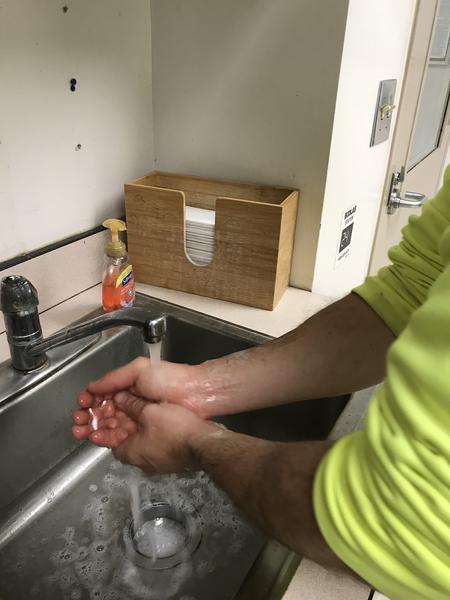 Feed mill employee washes hands.