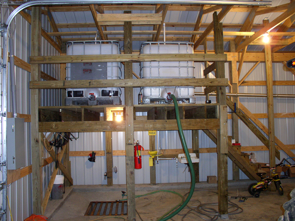 A pesticide mixing shed has a concrete pad edged with a lip and is sloped to drain to a sump tank. Two elevated tanks can be used to fill sprayer tanks.