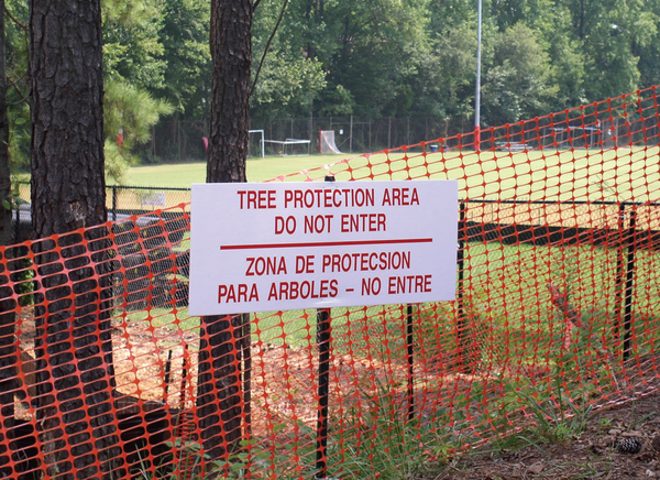 Photo of tree protection area zone sign in front of area marked by orange mesh fence