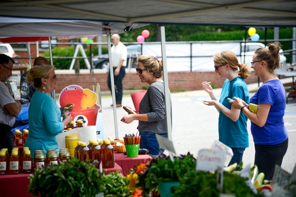 Customers talking with vendors at NC State Farmers Market