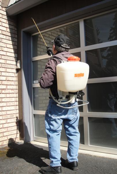 Pest control application to house exterior.