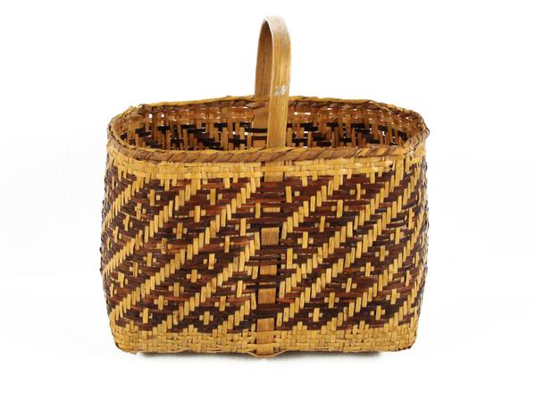 A woven, rectangular basket with a single handle