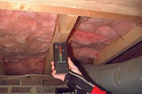Using moisture meter to check wood beams