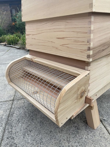 A screen cage or 'muzzle' used to prevent hornets from entering beehive.